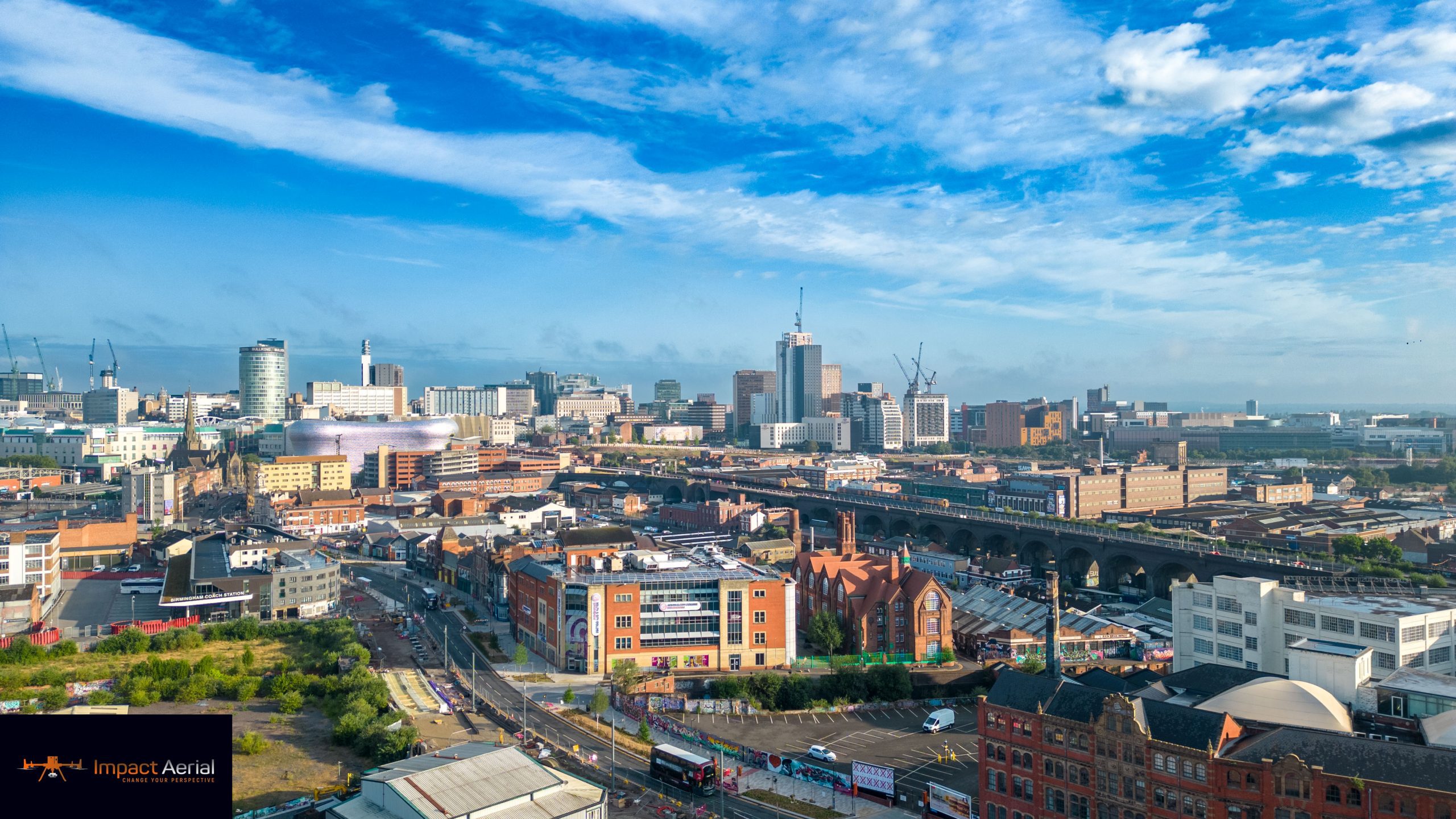 Aerial view over Digbeth and the Birmingham skyline at golden hour, captured by drone